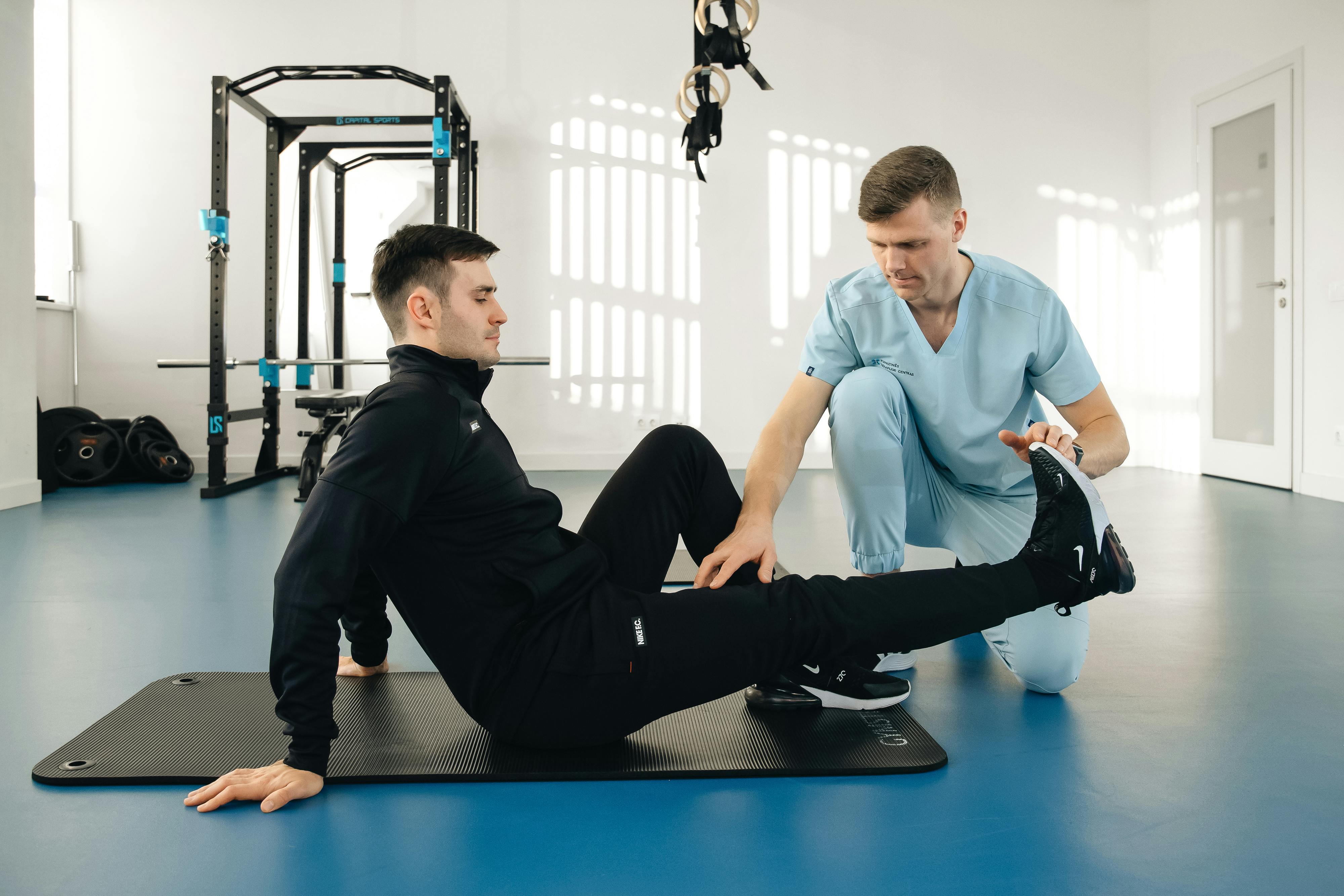 Physiotherapist assisting a patient with leg stretching